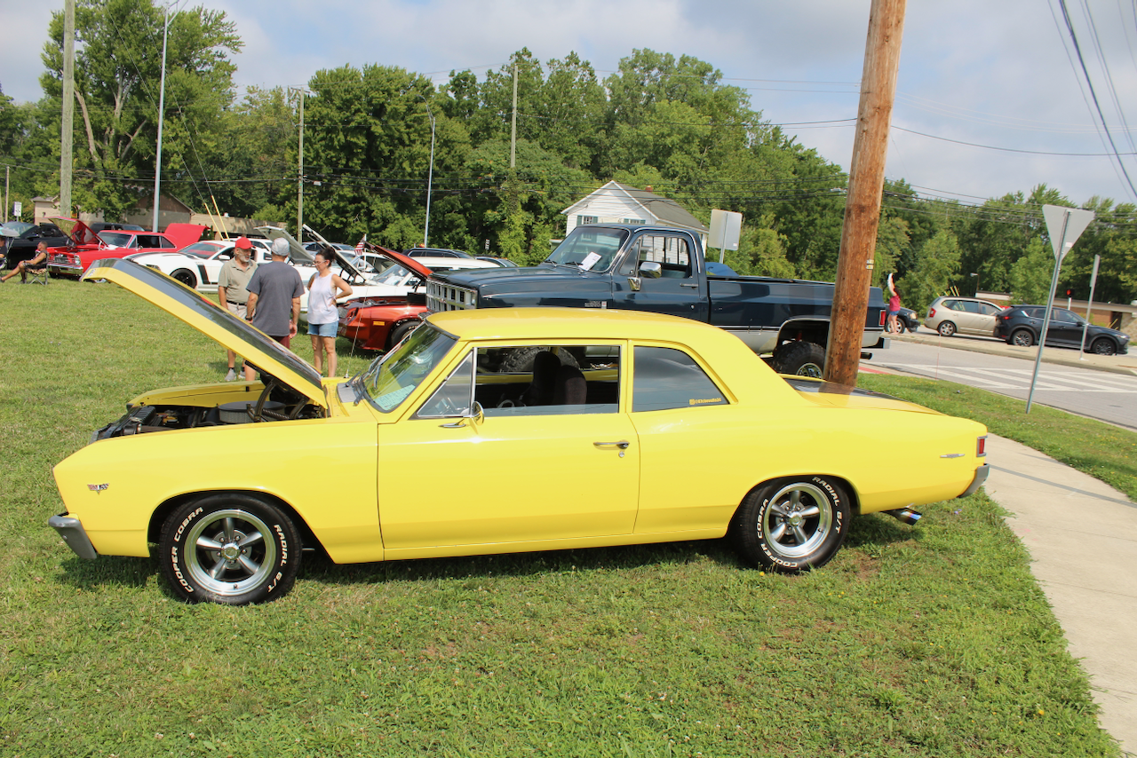1960s Chevrolet muscle car, yellow, hood open side profile view
